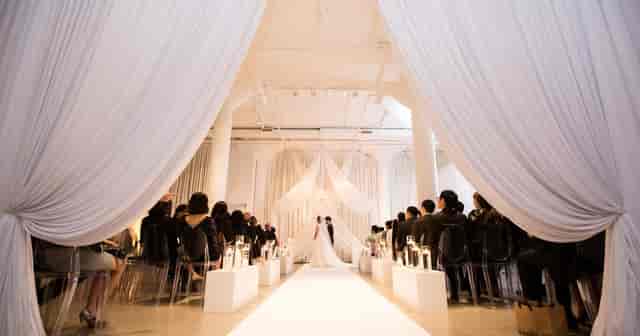 Elegant wedding ceremony in modern venue with intimate drapery and minimalist decor.