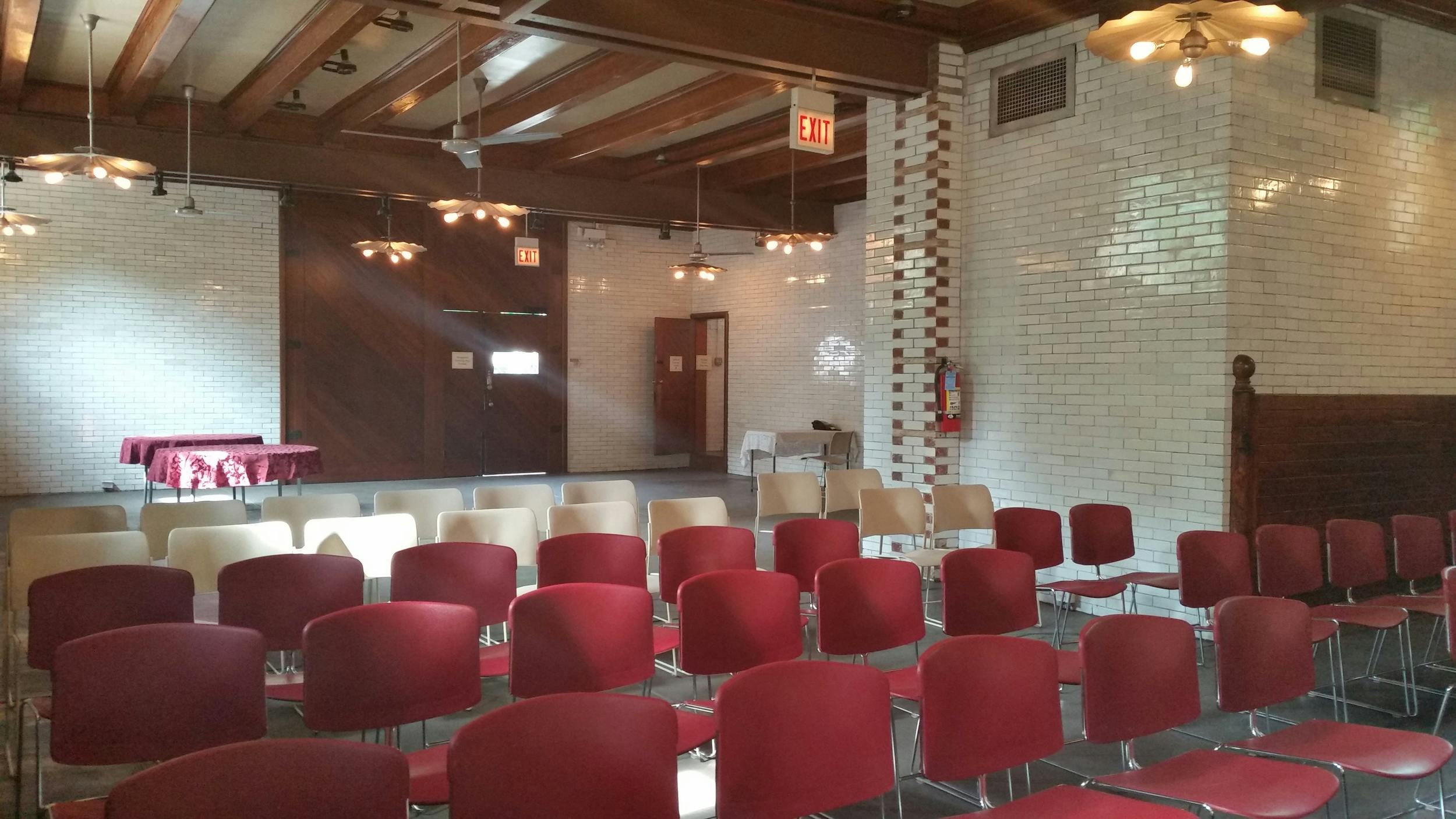 Versatile event space at Glessner House with red and beige chairs for workshops.