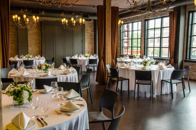 Elegant loft event space with floral centerpieces, ideal for corporate gatherings.
