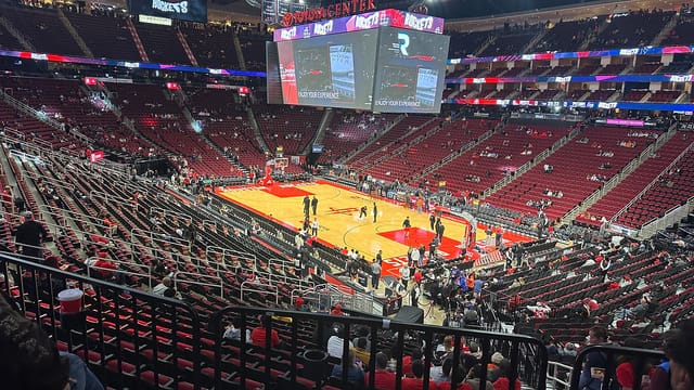 Empty Houston Toyota Center arena set up for sports events with spacious seating and screens.
