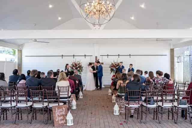 Wedding ceremony setup at Butler's Courtyard with chandelier and floral decor.