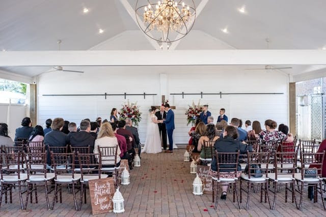 Wedding ceremony setup at Butler's Courtyard with chandelier and floral decor.