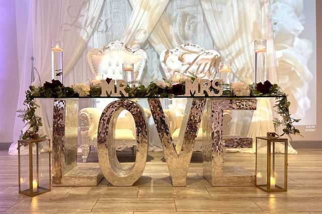 Elegant wedding head table with "MR" and "MRS" decor at Eden Events banquet hall.