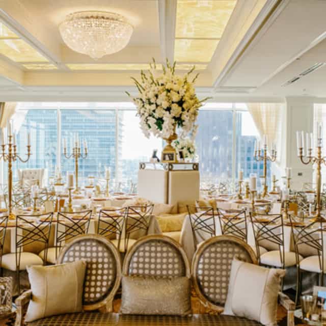 Elegant wedding banquet space with floral centerpiece and gold accents, ideal for upscale events.