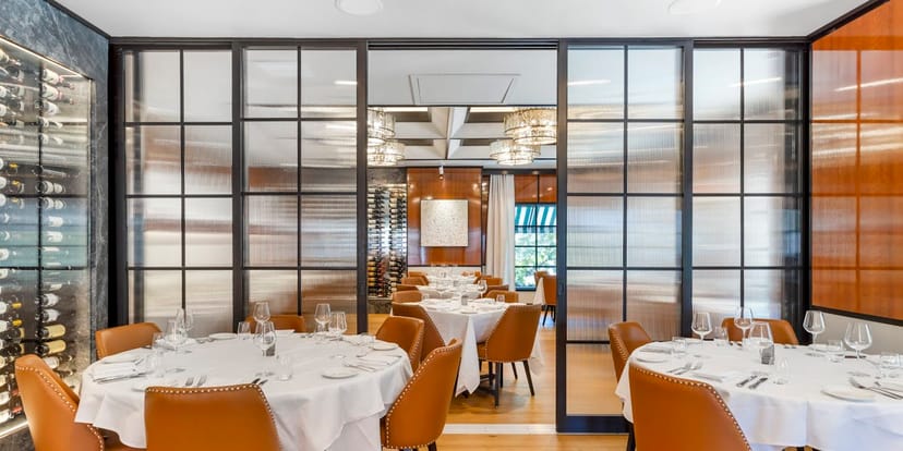 Sophisticated dining space with round tables for corporate events at La Griglia.