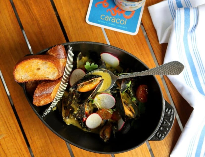 Mussels dish in cast-iron pot at Gusano Lounge, perfect for events and dining experiences.