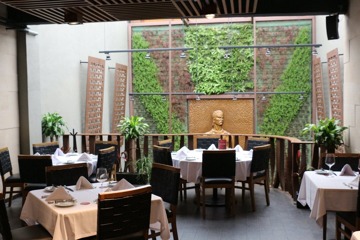 Elegant Fogo de Chão restaurant with lush greenery, ideal for corporate events and gatherings.