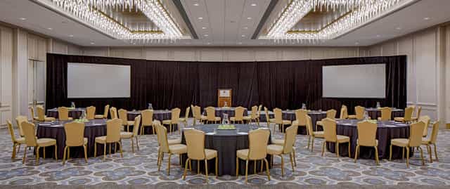 Conference room with round tables, ideal for corporate events and workshops.