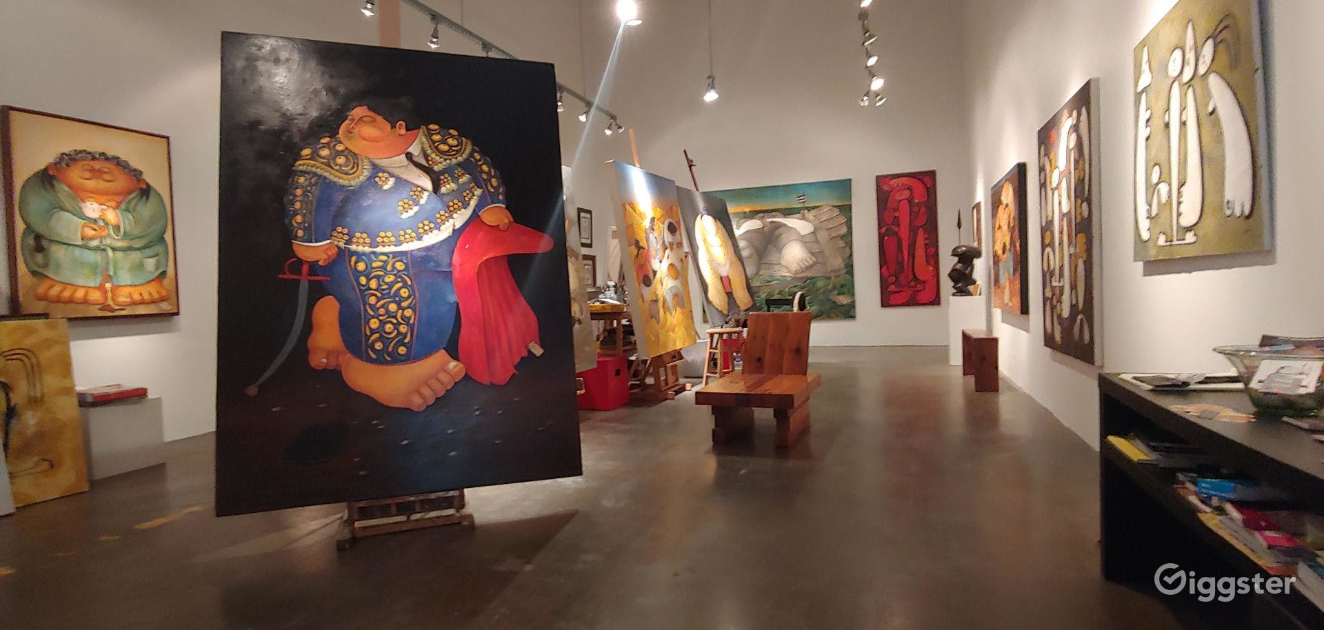 Spacious art gallery with vibrant paintings, perfect for networking events and private viewings.