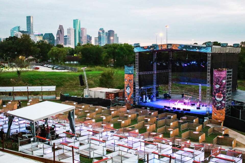 Outdoor amphitheater stage setup with city skyline for concerts and festivals.