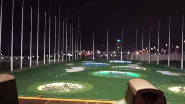 Illuminated Topgolf driving range at night, ideal for corporate events and team-building.