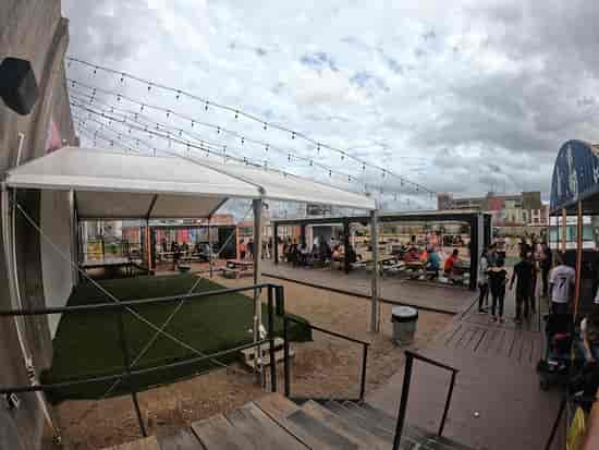 Outdoor event space at 8th Wonder Brewery with tent and string lights for gatherings.