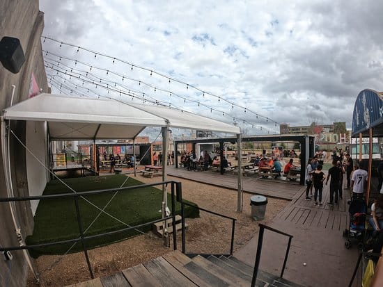 Outdoor event space at 8th Wonder Brewery with tent and string lights for gatherings.