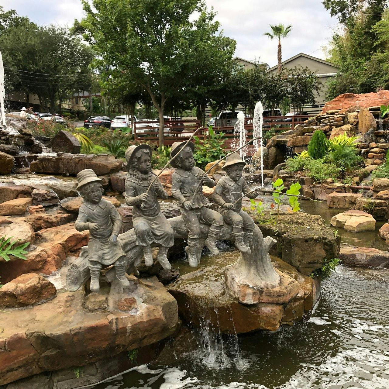 Charming outdoor event space with fountain and sculptures at Brenner's On The Bayou.