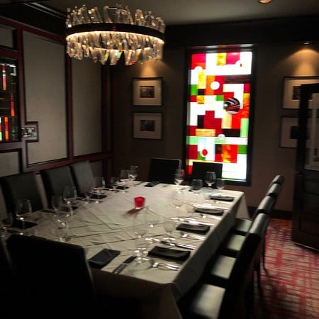 Elegant private dining room with stained glass, ideal for corporate events and intimate gatherings.