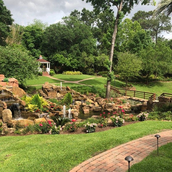 Outdoor wedding venue at Blue Bar with gazebo, lush greenery, and serene water feature.