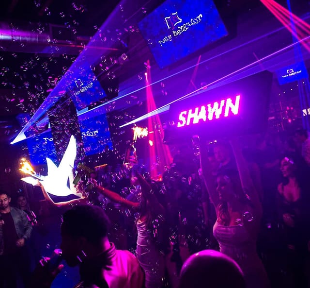 Vibrant nightlife event with dynamic lighting and energetic attendees celebrating.