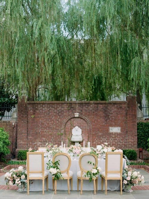 Outdoor wedding venue with brick backdrop and lush greenery at The Forum of Civics.