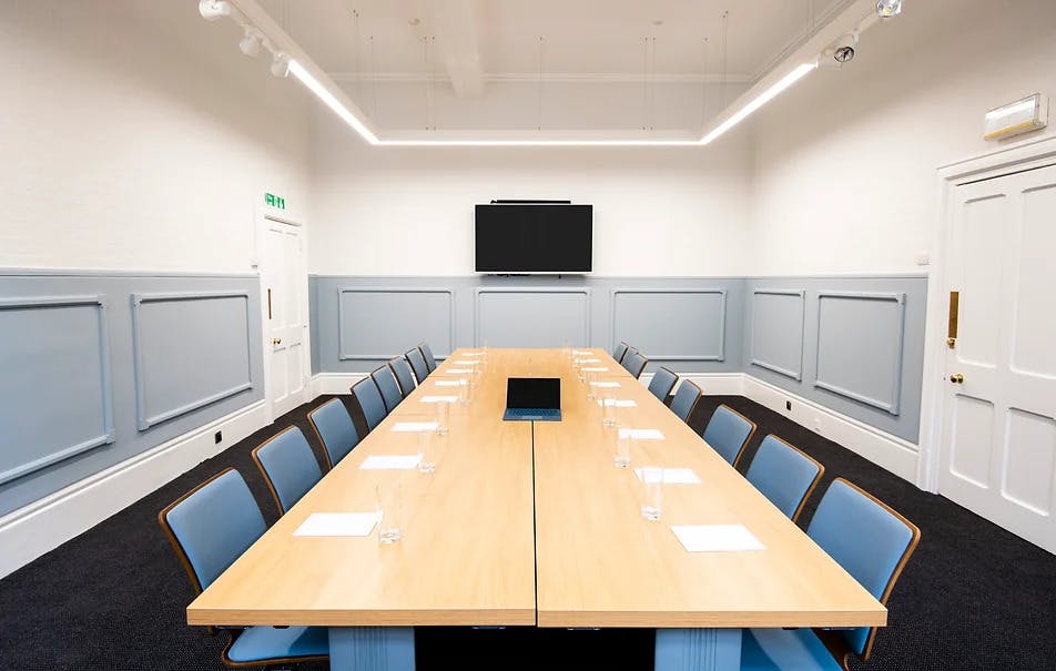 Modern conference room with long table, ideal for professional meetings and presentations.