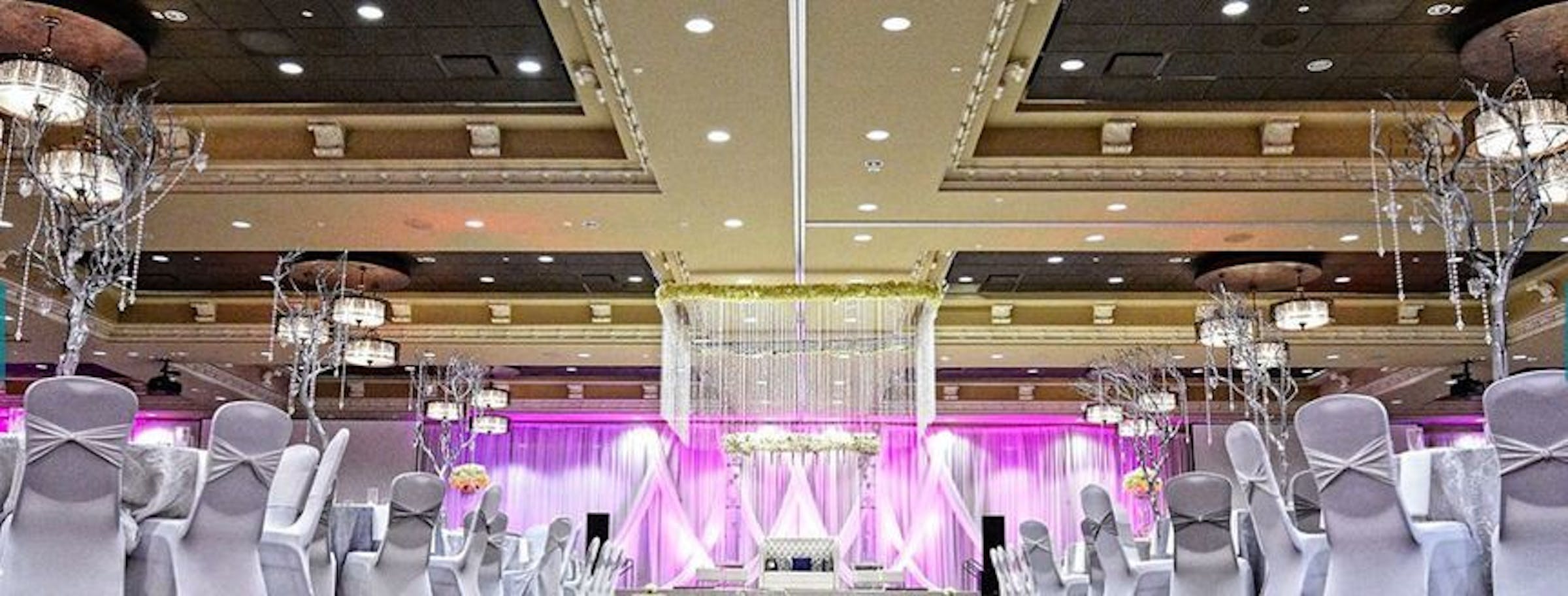 Elegant ballroom with pink lighting, perfect for weddings and upscale events.