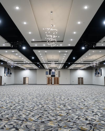 Spacious ULH Event Center stage with modern chandeliers for conferences and banquets.