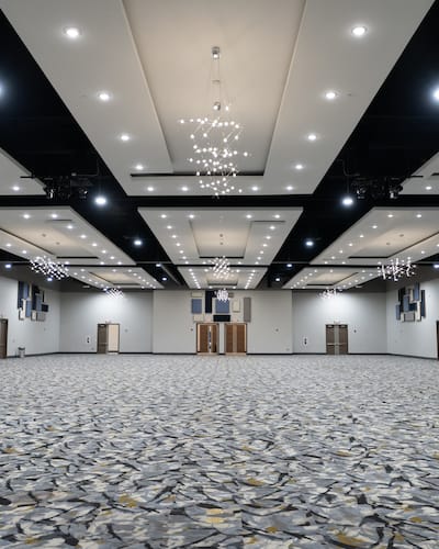Spacious ULH Event Center stage with modern chandeliers for conferences and banquets.