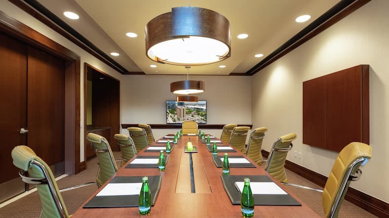 Modern conference room with wooden table at Embassy Suites Houston for meetings and events.