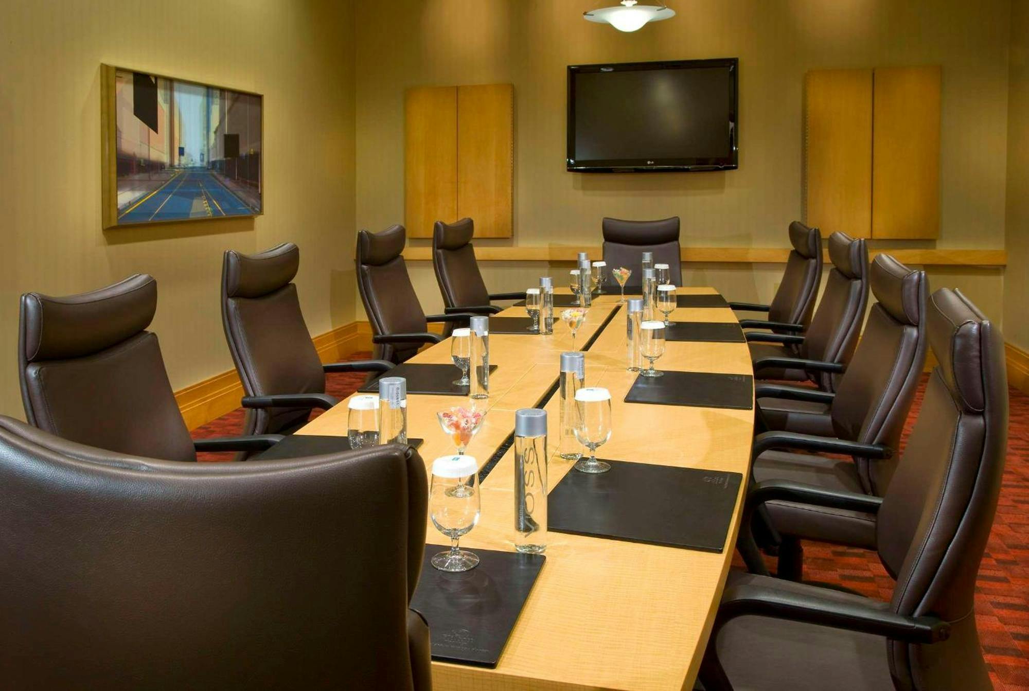 Meeting room with oval table and leather chairs at Embassy Suites Houston for corporate events.