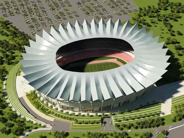 Modern Dubai Sports City stadium with angular roof, ideal for sports and concerts.