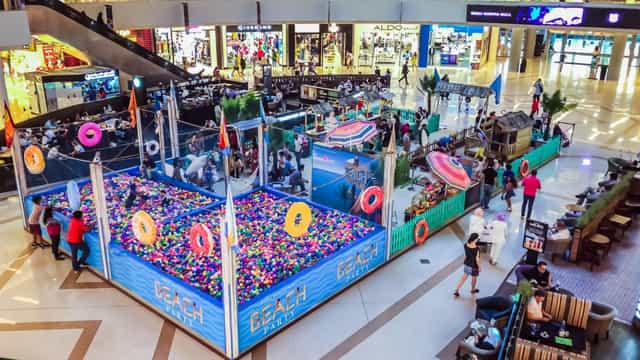 Beach-themed event setup with inflatable pools at Dubai Marina Mall for family-friendly activities.
