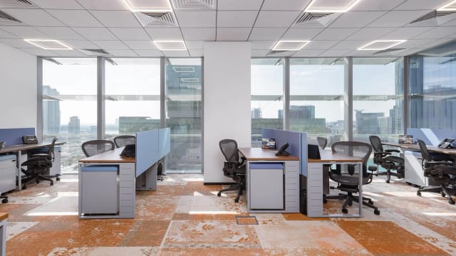 Modern open office in Executive House, featuring ergonomic workstations for collaborative meetings.