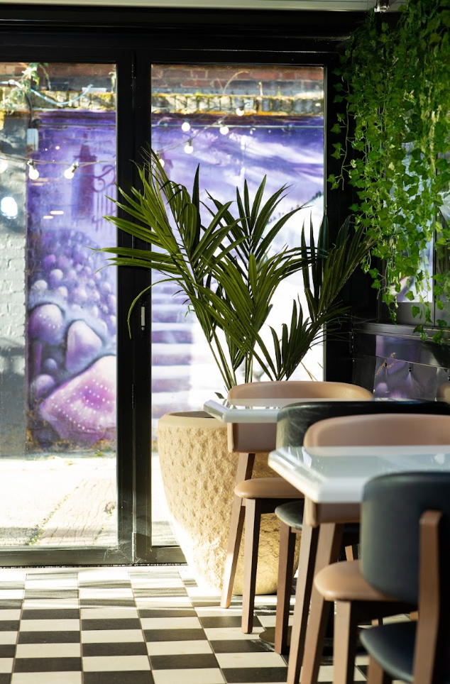 Stylish meeting space at Whole Venue, featuring modern furniture and vibrant greenery. - Banner