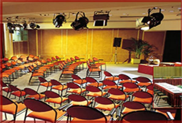 Banquet hall in India Habitat Centre, featuring orange chairs for seminars and presentations.