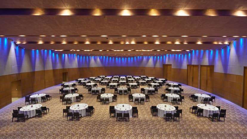 Spacious Banquet Hall in Aerocity set for a large conference with round tables.