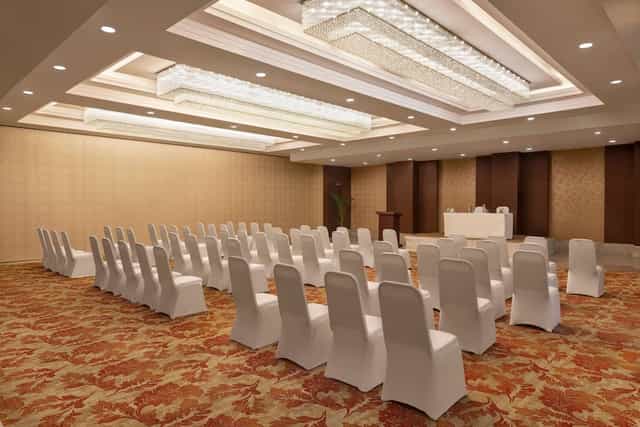 Meeting room at Ramada by Wyndham, white chairs for corporate events and meetings.