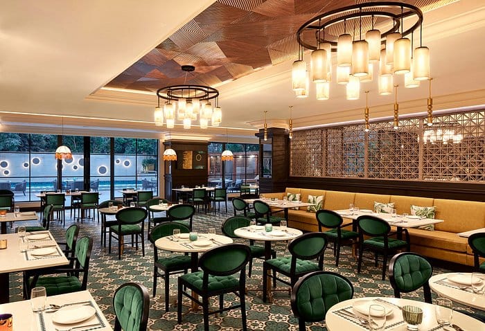 Stylish restaurant setting with plush green chairs for intimate meetings and events.