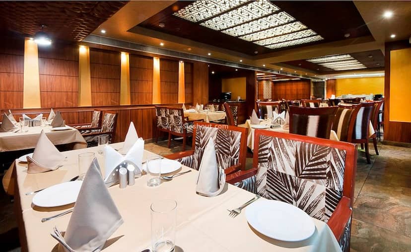 Elegant Banquet Hall with polished table settings for events and gatherings at Hotel Regent Grand.