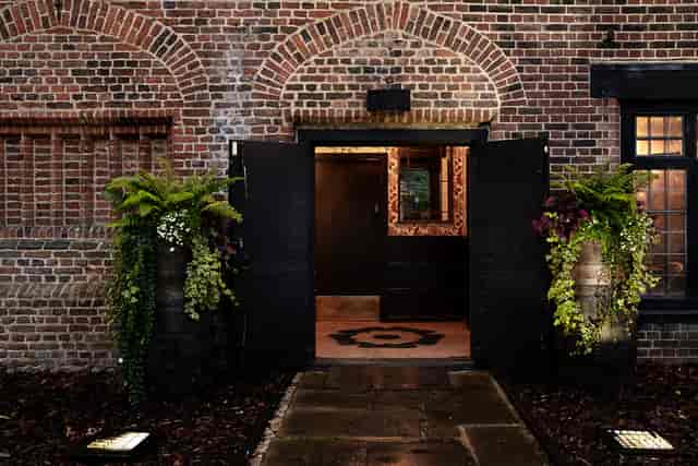 Tudor Barn Eltham entrance with rustic brick facade, ideal for events and gatherings.