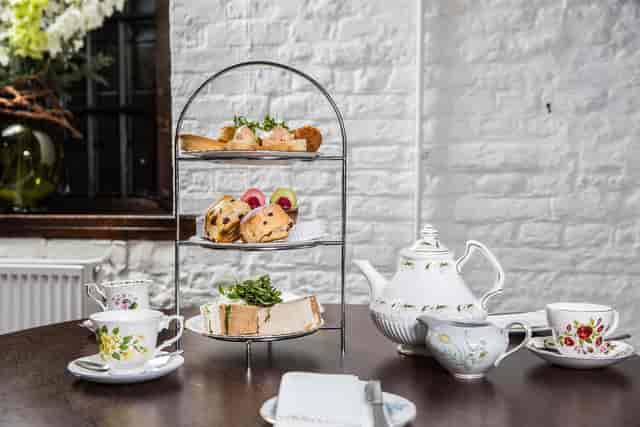 Elegant afternoon tea setup at Moat Terrace, Tudor Barn Eltham for corporate events.