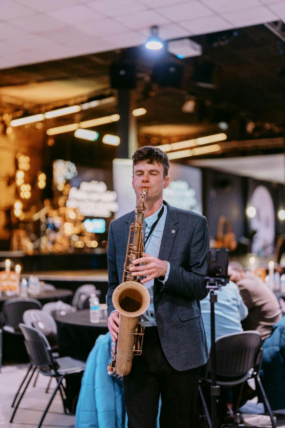 Musician playing saxophone in upscale event at The Hope Centre Auditorium.