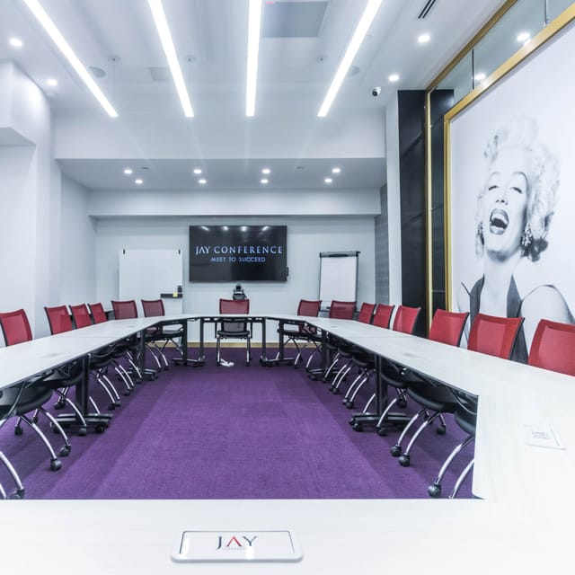 Modern conference room with U-shaped table, bright lighting, and Marilyn Monroe artwork.