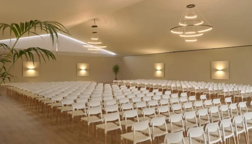 Spacious event venue with white chairs, perfect for conferences and workshops.