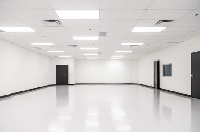 Spacious meeting room with white walls for corporate events and workshops.