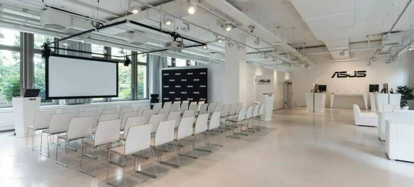 Modern event space in Berliner Freiheit with white chairs, perfect for corporate meetings.
