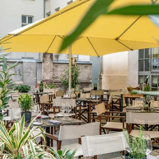 Outdoor dining at Stadtbad Oderberger with vibrant umbrellas for receptions and gatherings.