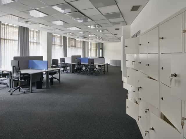 Modern coworking space with ergonomic workstations for meetings and training events.