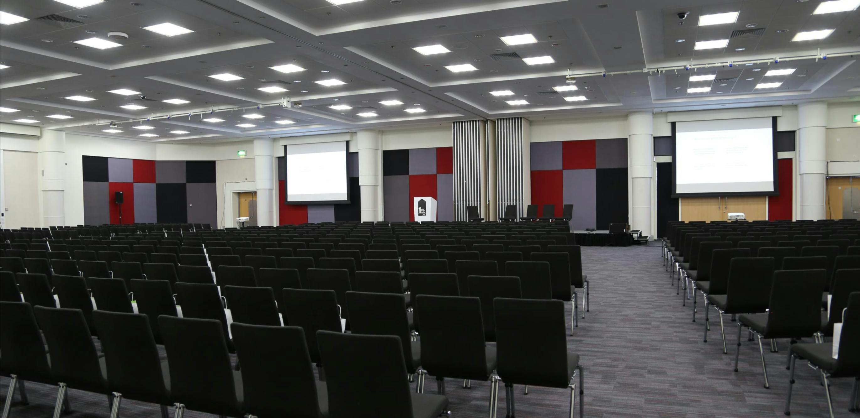 Spacious conference room at NEC Birmingham with dark green chairs for events and seminars.