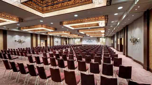 Spacious Hilton Berlin meeting room with plush seating for corporate events.