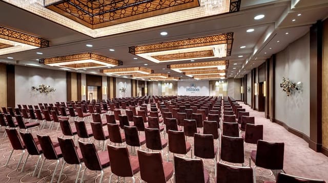 Spacious Hilton Berlin meeting room with plush seating for corporate events.