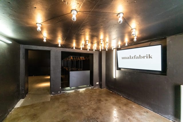 Versatile event space with industrial-chic design for corporate meetings and creative events.